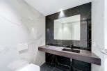Experience modern luxury in this stunning bathroom, featuring elegant marble-patterned tiles on the walls and floor.