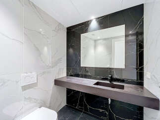 Experience modern luxury in this stunning bathroom, featuring elegant marble-patterned tiles on the walls and floor.