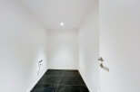 Discover this modern, minimalist room featuring sleek black marble tile flooring and crisp white walls.