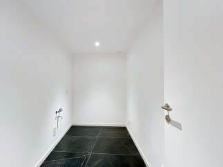 Discover this modern, minimalist room featuring sleek black marble tile flooring and crisp white walls.