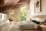 Luxurious bedroom with sloped ceilings and large windows offering abundant natural light and forest views.