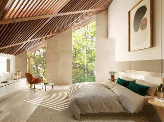 Luxurious bedroom with sloped ceilings and large windows offering abundant natural light and forest views.
