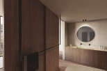 Luxurious bathroom with wooden wall paneling and a sleek, round mirror.