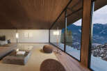 Mountain view living room with floor to ceiling windows, hardwood floors, and cozy seating.
