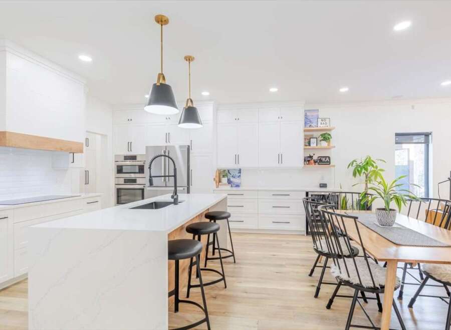 This stunning kitchen boasts a modern design with sleek white cabinetry and a spacious island.