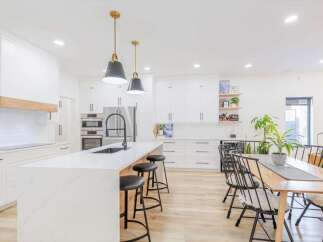 This stunning kitchen boasts a modern design with sleek white cabinetry and a spacious island.