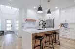 This stunning kitchen boasts a modern design with sleek white cabinetry and a spacious island.