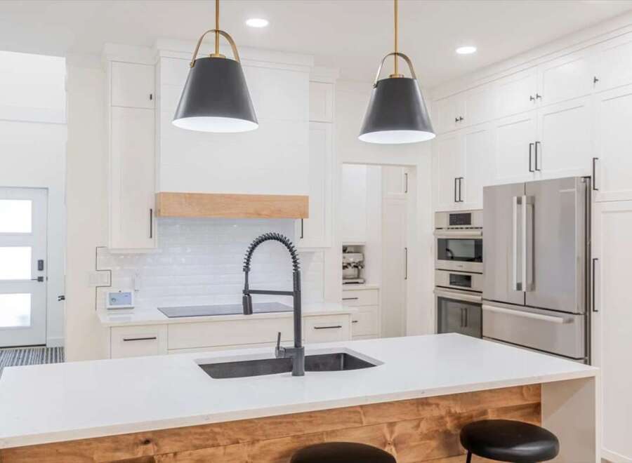 This stunning kitchen boasts a modern design with sleek white cabinetry and a spacious island.