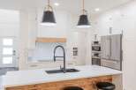 This stunning kitchen boasts a modern design with sleek white cabinetry and a spacious island.