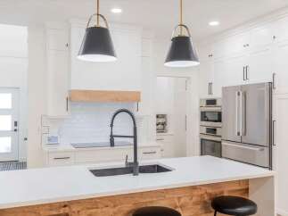 This stunning kitchen boasts a modern design with sleek white cabinetry and a spacious island.