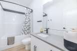 Step into a modern bathroom oasis! This space features a sleek vanity with a gray countertop and black fixtures.