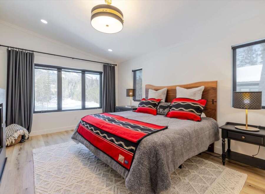 This cozy bedroom features a stunning wooden headboard and a plush, inviting bed.