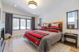 This cozy bedroom features a stunning wooden headboard and a plush, inviting bed.