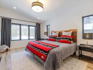 This cozy bedroom features a stunning wooden headboard and a plush, inviting bed.