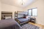 This cozy bedroom features a stylish bunk bed and a comfortable single bed, perfect for accommodating guests or family members.
