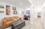 This stunning property boasts a cozy living room with a comfortable leather sofa and unique artwork.