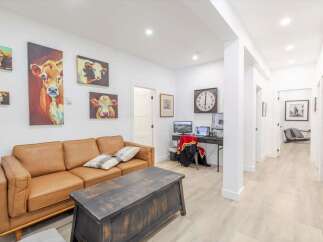 This stunning property boasts a cozy living room with a comfortable leather sofa and unique artwork.