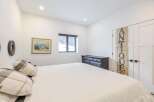 This bedroom offers a serene retreat with its bright, airy ambiance and minimalist design.