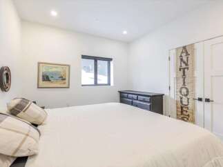 This bedroom offers a serene retreat with its bright, airy ambiance and minimalist design.