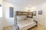 This cozy bedroom features a stylish bunk bed, perfect for accommodating guests or creating a fun space for kids.