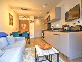 This stunning apartment boasts a modern open-plan kitchen and living area, perfect for entertaining.