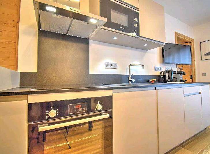 Modern kitchen with built-in oven, microwave, and sleek cabinetry.