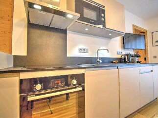 Modern kitchen with built-in oven, microwave, and sleek cabinetry.