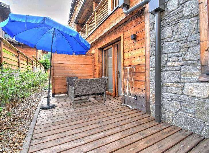 This stunning property boasts a private patio with a wooden deck, perfect for outdoor relaxation.