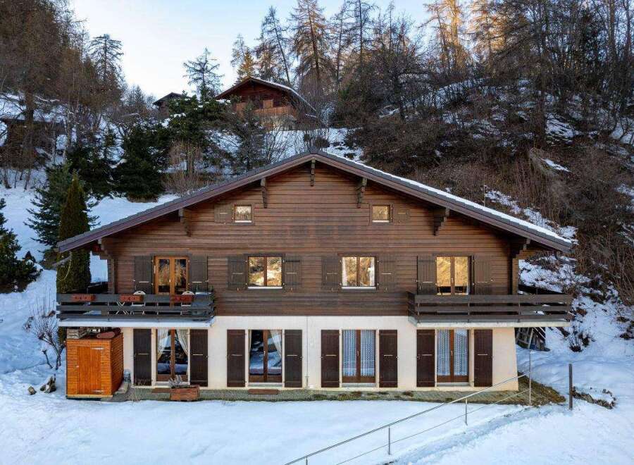 Discover the charm of this stunning wooden chalet nestled in a snowy landscape.