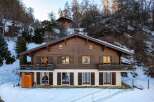 Discover the charm of this stunning wooden chalet nestled in a snowy landscape.