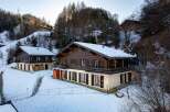 Discover the charm of these stunning wooden chalets nestled in a snowy landscape.
