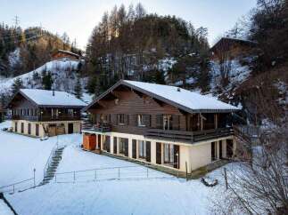 Discover the charm of these stunning wooden chalets nestled in a snowy landscape.