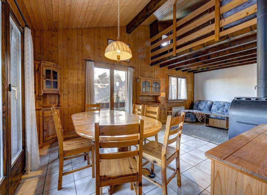Cozy cabin dining area with a rustic wooden table and chairs, perfect for family meals.