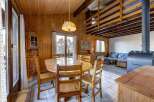 Cozy cabin dining area with a rustic wooden table and chairs, perfect for family meals.