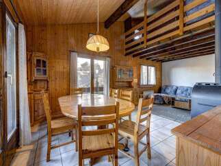 Cozy cabin dining area with a rustic wooden table and chairs, perfect for family meals.