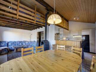 This charming property boasts a cozy living space with a unique wooden ceiling design.