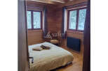 Cozy bedroom with wooden walls and ceiling, creating a warm and inviting atmosphere.