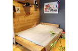 Discover a cozy bedroom with a unique wooden bed frame and a stylish painting.