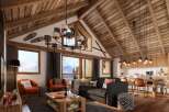 This stunning chalet boasts a spacious open-plan living area with vaulted wooden ceilings and large windows offering breathtaking mountain views.