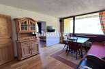 Discover a charming property with a cozy living space, featuring a wooden cabinet and a welcoming dining area.