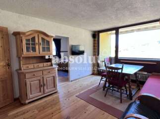 Discover a charming property with a cozy living space, featuring a wooden cabinet and a welcoming dining area.