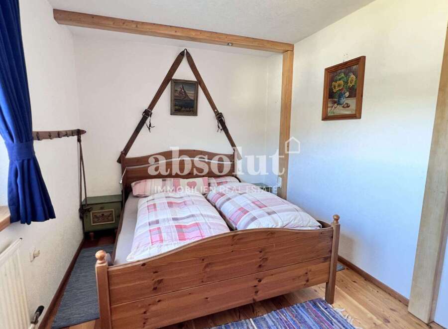 Charming bedroom with a rustic wooden bed frame and cozy bedding.
