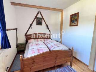 Charming bedroom with a rustic wooden bed frame and cozy bedding.