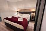 Discover a cozy bedroom featuring a comfortable bed with a stylish red quilt.