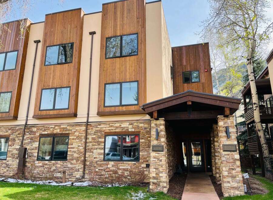 Discover modern luxury at this stunning property featuring a blend of natural stone and warm wood accents.