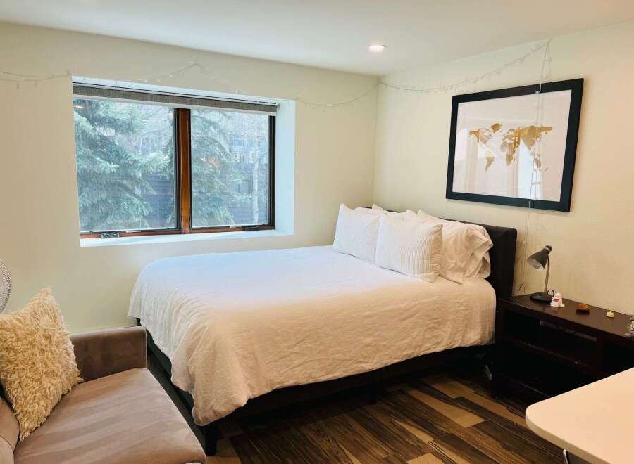 This cozy bedroom features a comfortable bed with crisp white linens, perfect for a relaxing retreat.