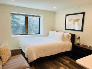 This cozy bedroom features a comfortable bed with crisp white linens, perfect for a relaxing retreat.