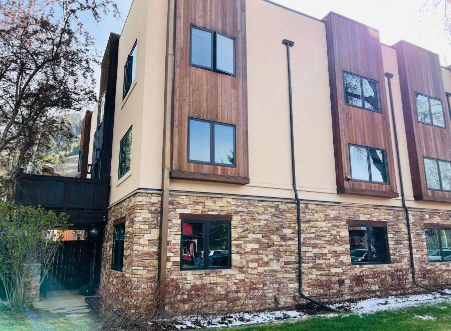 Discover modern living in this stunning property, showcasing a beautiful blend of stone and wood exterior.
