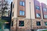 Discover modern living in this stunning property, showcasing a beautiful blend of stone and wood exterior.