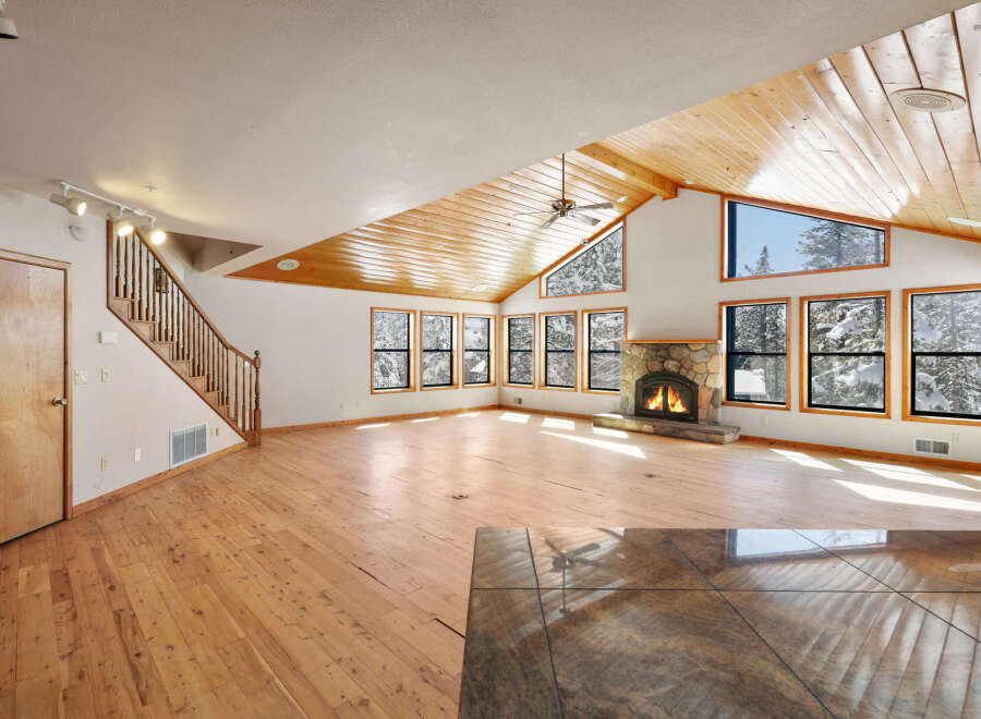 This stunning home boasts a spacious open floor plan with gleaming hardwood floors and a cozy stone fireplace, perfect for entertaining guests or relaxing by the fire.